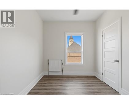 A room with a window showing a building outside.