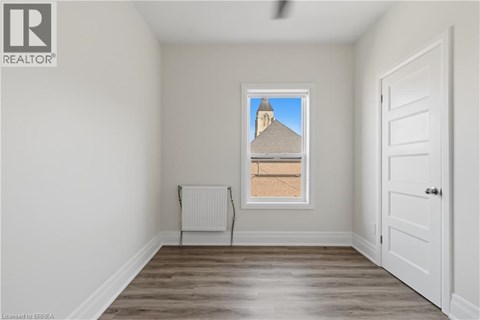 A room with a window showing a building outside.