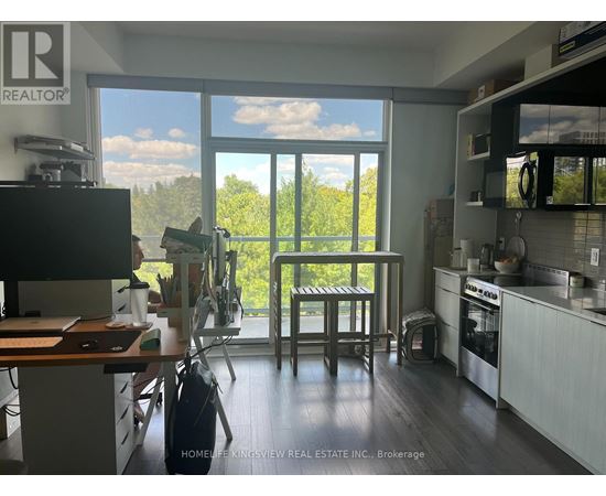 A kitchen with a table and chairs in front of a large window.