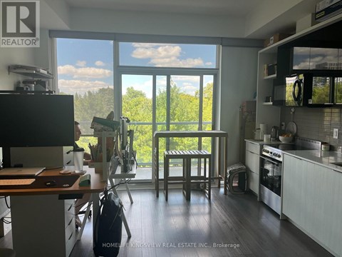 A kitchen with a table and chairs in front of a large window.