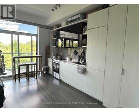 A kitchen with white cabinets and a wooden floor.