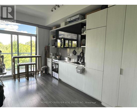A kitchen with white cabinets and a wooden floor.