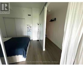 A bedroom with a bed, a dresser, and a mirror.