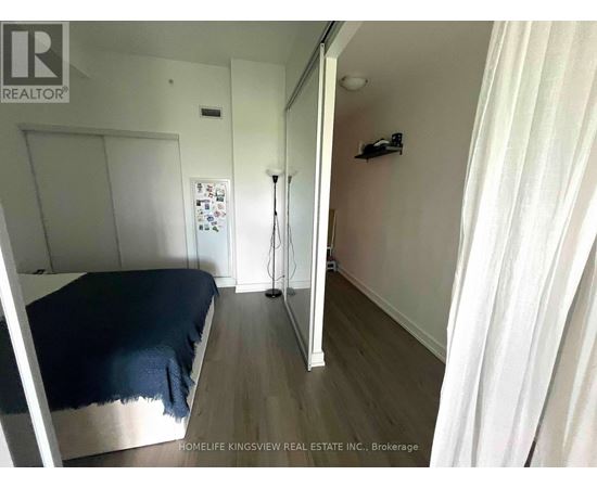 A bedroom with a bed, a dresser, and a mirror.