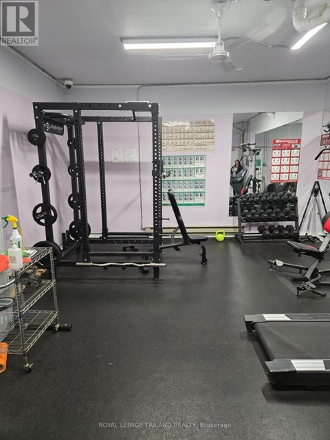 A gym with a squat rack, weight bench, and other equipment.