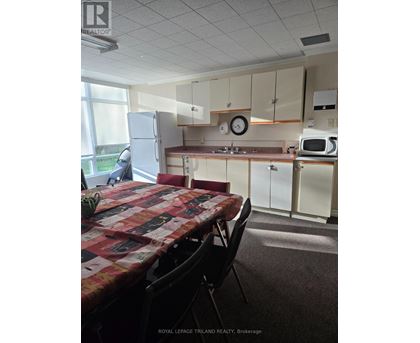 A kitchen with a table and chairs in front of it.