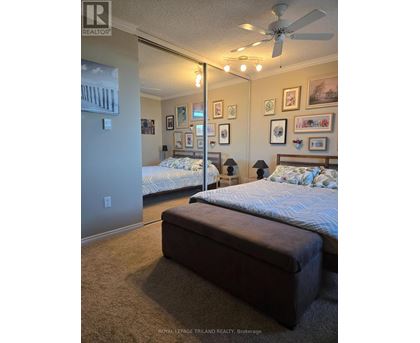 A bedroom with two beds and a ceiling fan.