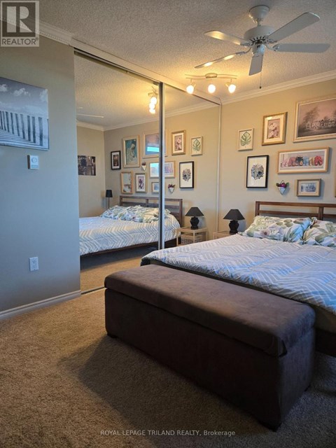 A bedroom with two beds and a ceiling fan.
