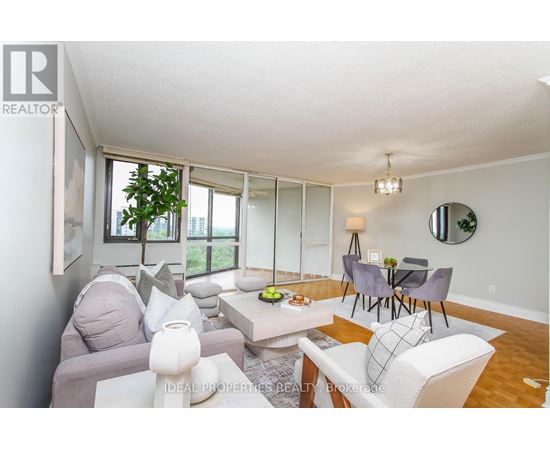 A living room with a grey couch, a white couch, a coffee table, and a dining table with chairs.