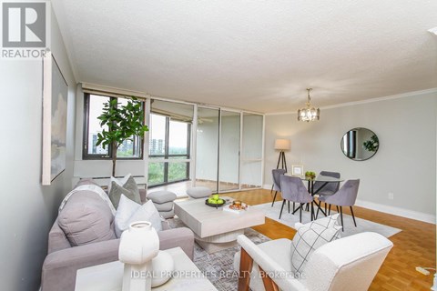 A living room with a grey couch, a white couch, a coffee table, and a dining table with chairs.