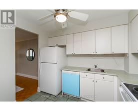 A small kitchen with white cabinets and a blue dishwasher.