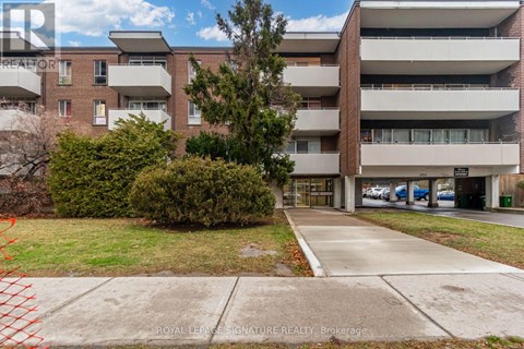A large apartment complex with a parking lot in front.