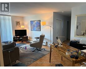 A living room with a television, a chair, and a table.