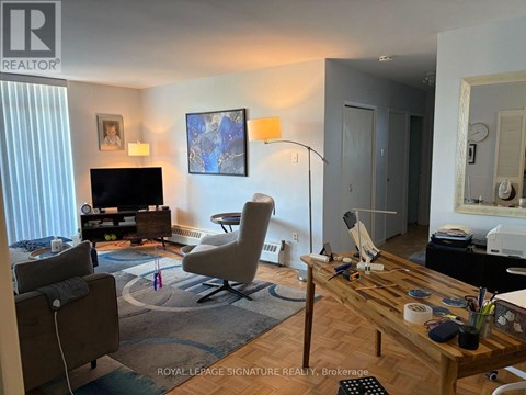 A living room with a television, a chair, and a table.