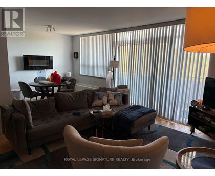 A living room with a brown couch and a television.