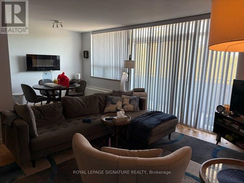 A living room with a brown couch and a television.