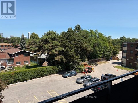 A parking lot with cars and a building in the background.