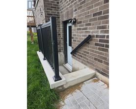A black metal railing on a brick wall.