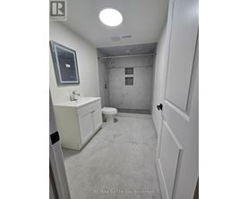 A bathroom with a toilet, sink, and mirror.