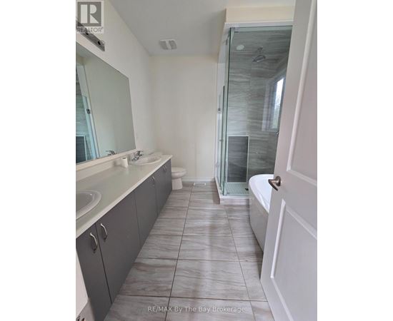 A bathroom with a glass shower door and a white bathtub.