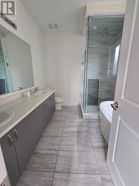 A bathroom with a glass shower door and a white bathtub.
