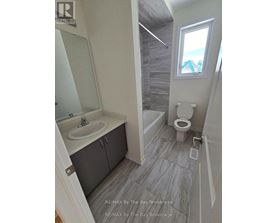 A bathroom with a toilet, sink, and a window.