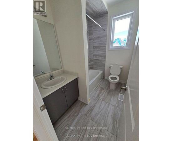 A bathroom with a toilet, sink, and a window.
