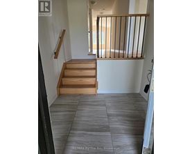 A hallway with a staircase and a balcony.