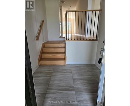 A hallway with a staircase and a balcony.