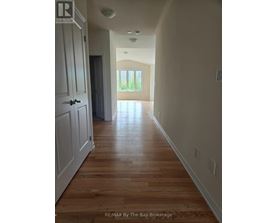 A long hallway with wood floors and white walls.