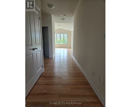 A long hallway with wood floors and white walls.