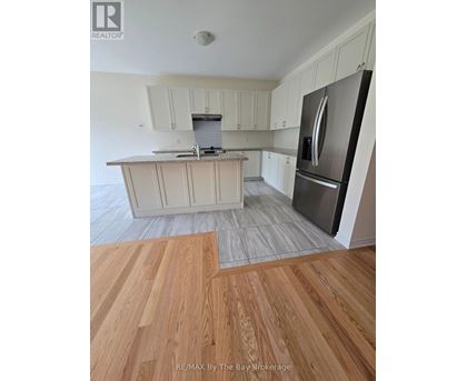 A kitchen with white cabinets and a stainless steel refrigerator.