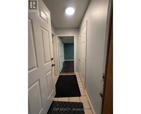 A hallway with a black and white rug on the floor.