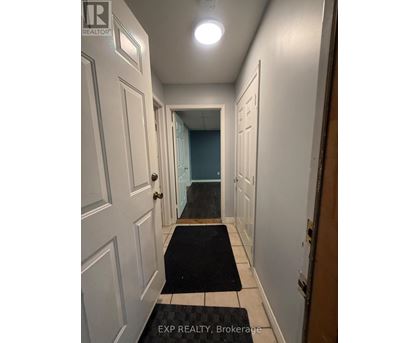 A hallway with a black and white rug on the floor.