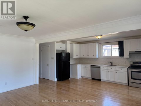 A kitchen with white cabinets and a black refrigerator.