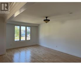 A room with a ceiling fan and a window overlooking a street.