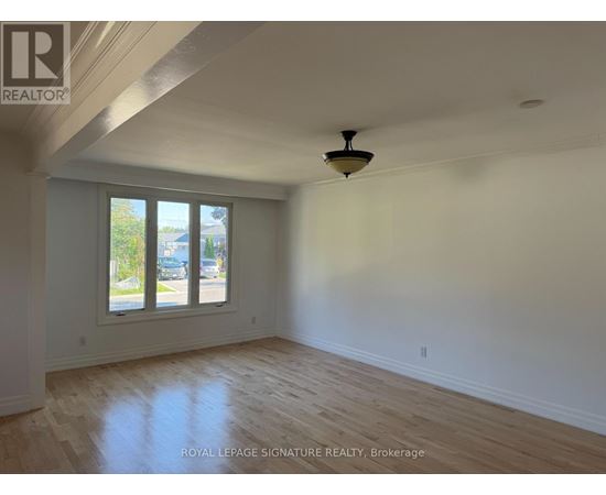 A room with a ceiling fan and a window overlooking a street.