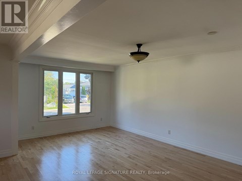 A room with a ceiling fan and a window overlooking a street.