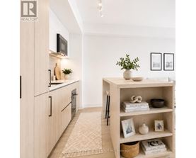 A modern kitchen with a wooden cabinet and a white shelf with various items on it.