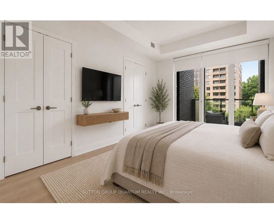 A bedroom with a large bed and a flat screen TV mounted on the wall.