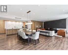 A modern dining room with a wooden floor and white chairs.