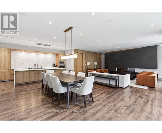 A modern dining room with a wooden floor and white chairs.
