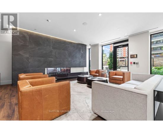 A modern living room with a grey sofa and brown leather armchairs.