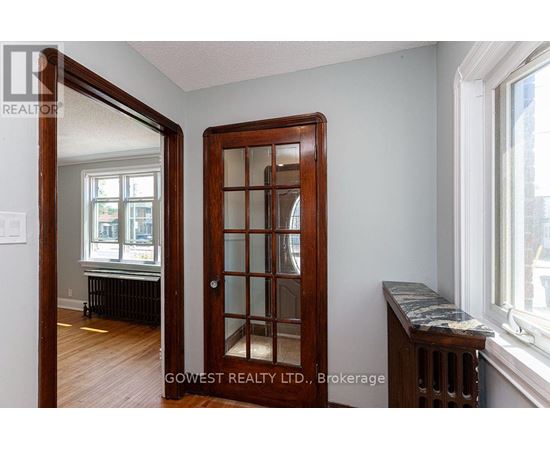 A room with a wooden door and a marble bench.