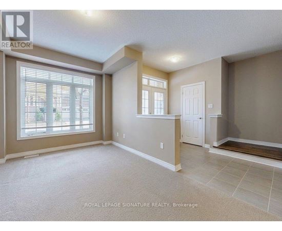 A spacious room with a large window and a door is on the market with Royal LePage Signature Realty in Brokerage.