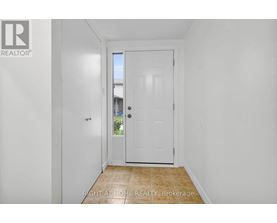 A white door in a hallway with a brokerage logo on the wall.