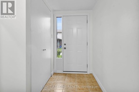 A white door in a hallway with a brokerage logo on the wall.
