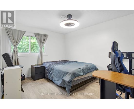 A bedroom with a bed, desk, and chair.