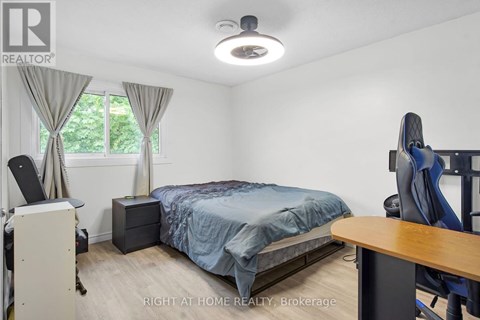 A bedroom with a bed, desk, and chair.