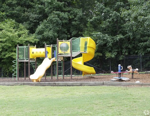 A yellow slide in a playground.